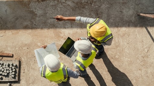Ariel view of construction managers in hi-vis and hard hats on a building site