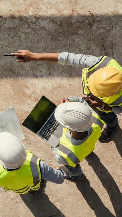 Ariel view of construction managers in hi-vis and hard hats on a building site