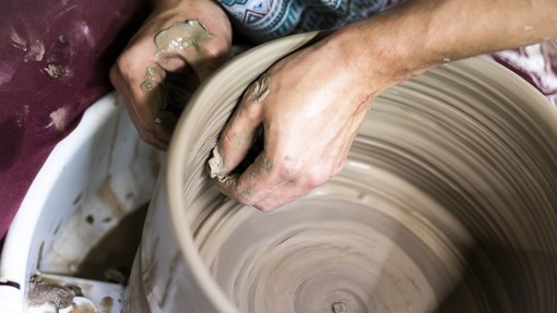 Close up of a student using a pottery wheel.