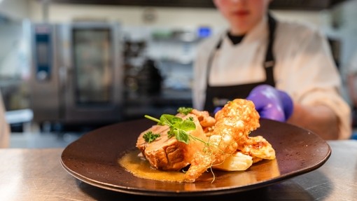 Student serving food at the pass