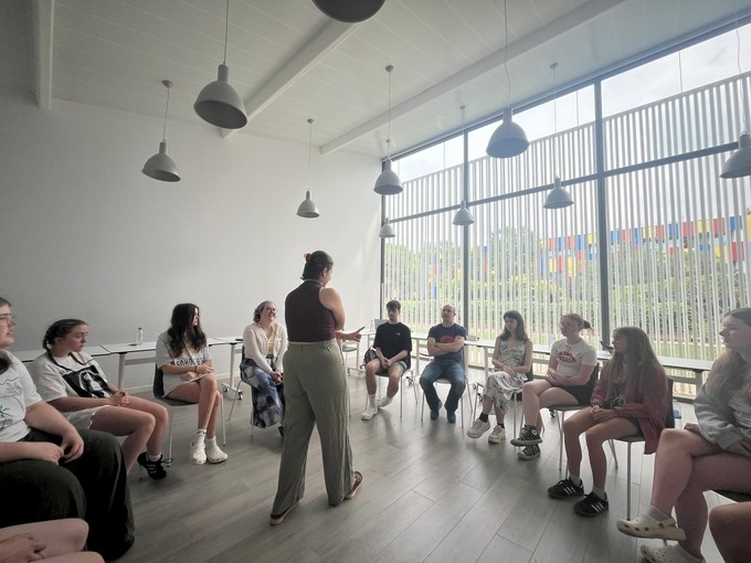 Students in a group, seated in a circle with a facilitator