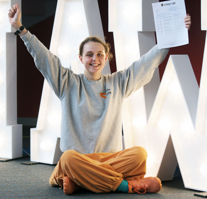 Sitting on the floor with arms in the air certificate in hand