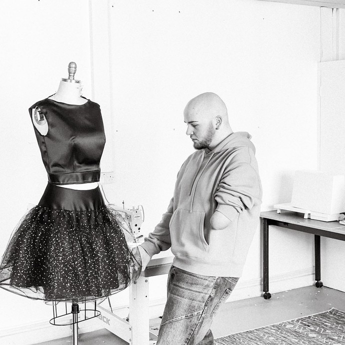 Ryan Rix adjusting dress on mannequin 