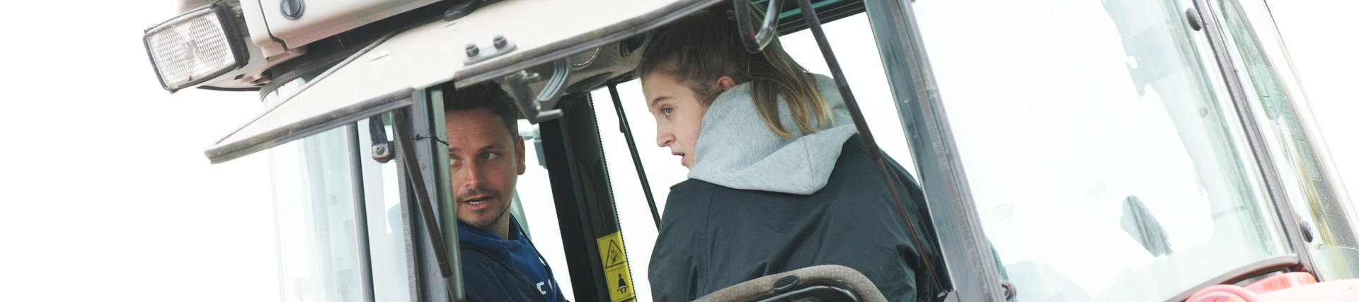 A student learns how to drive a tractor.