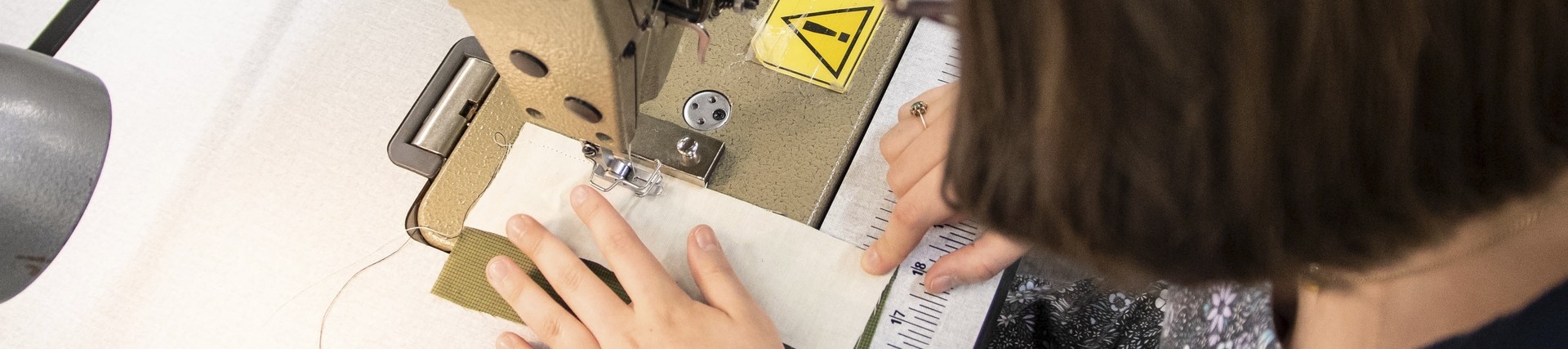 A student uses a sowing machine. 