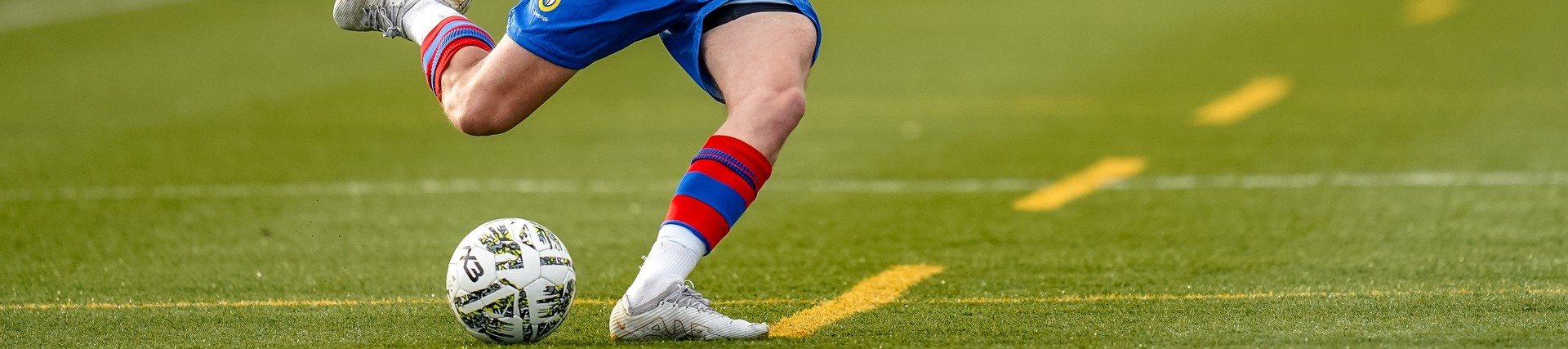 Student in blue uniform playing football.