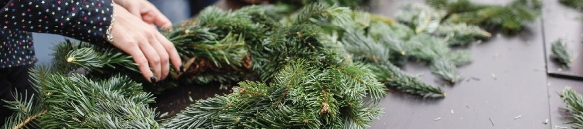 Close-up of hands during a craft session, creating a wreath