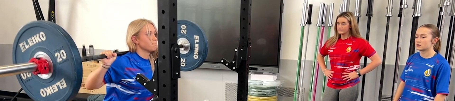 A student lifting weights in the gym.