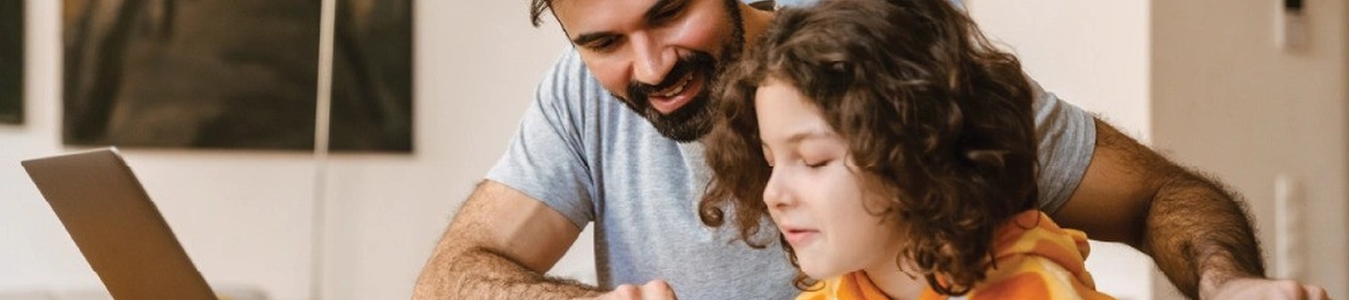 Father and daughter reading through schoolwork while sitting at a table