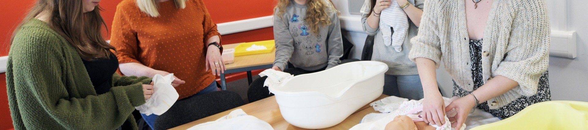 Students practice nursing a baby.