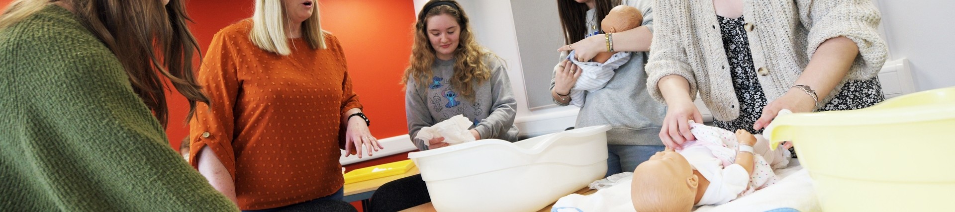 Students practice nursing a baby.