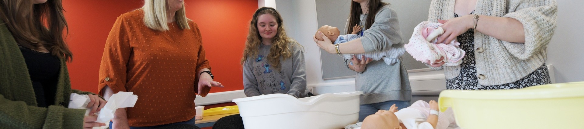 Students practice nursing a baby.