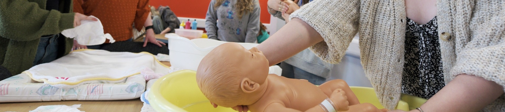 A student practices nursing a baby.