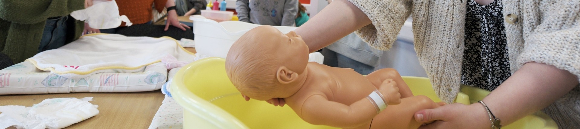 A student practices nursing a baby.