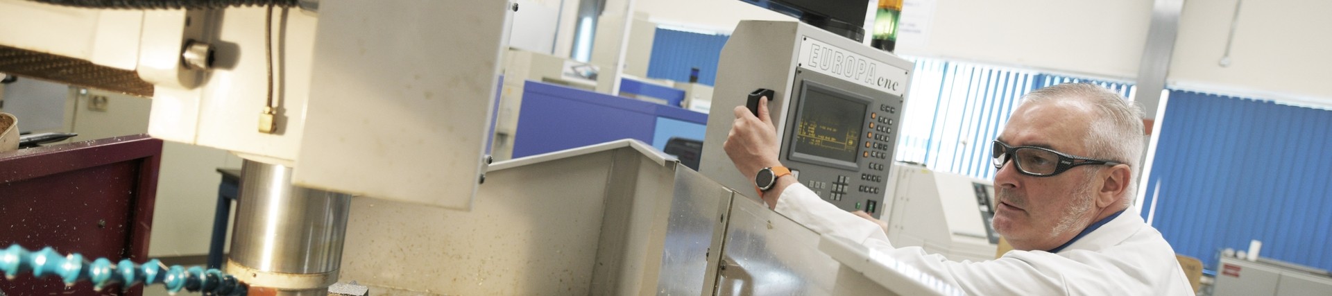 A lecturer programs a cutting machine.