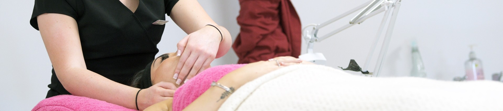 A student applies a facial treatment.