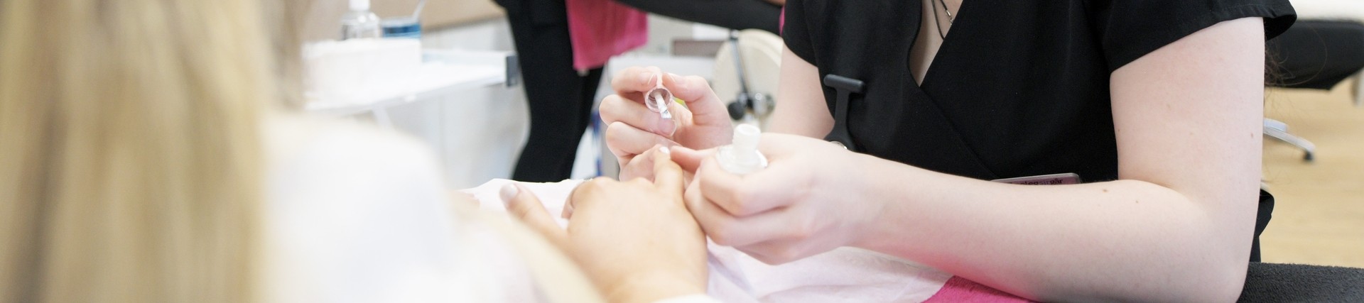 A student practices doing someones nails.