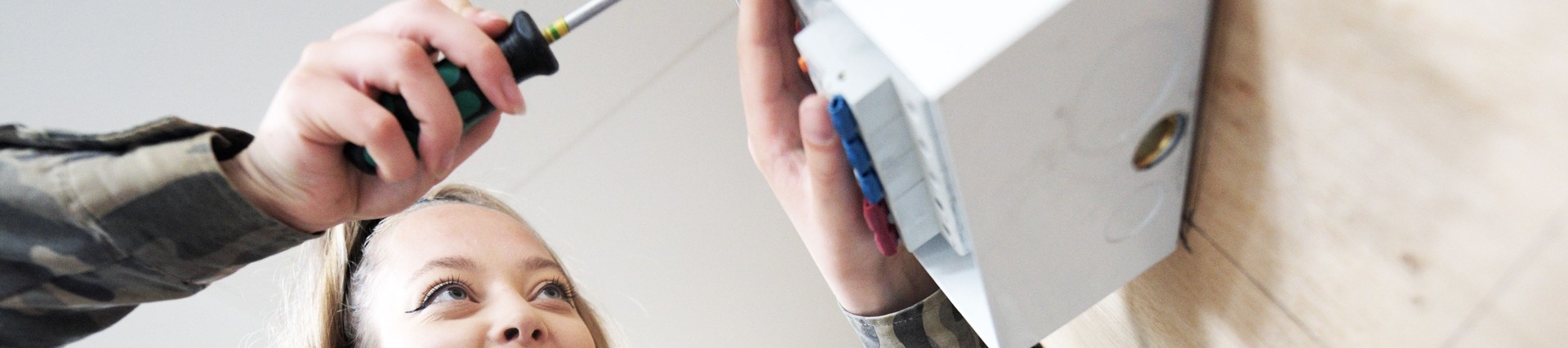 A student works on an electrical box.