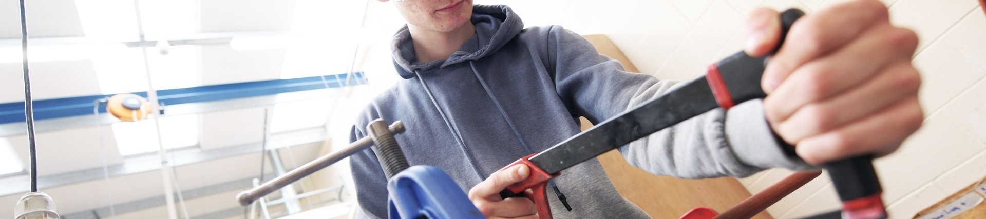 A student uses a saw.