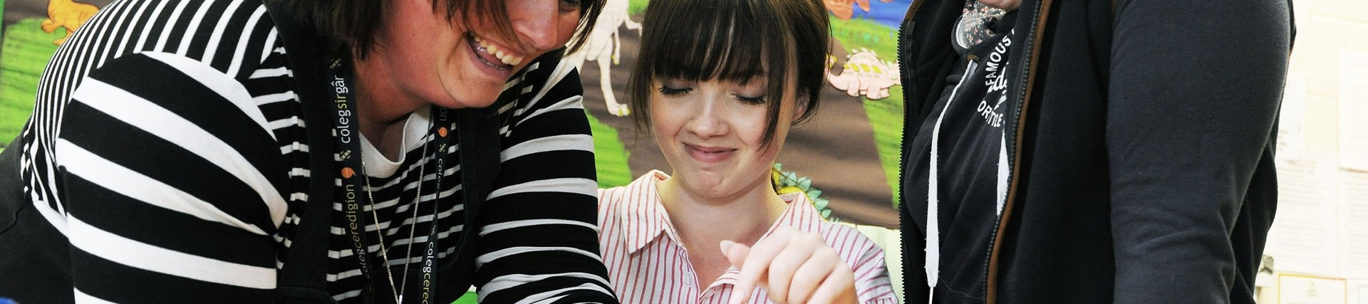 A lecturer with a student demonstrating on a baby learning mannequin