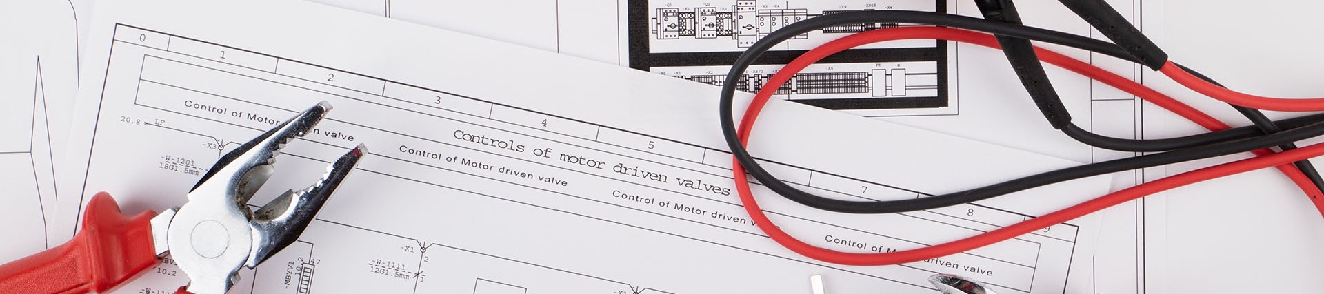 Top-down shot of electrical tools, including pliers and voltage tester