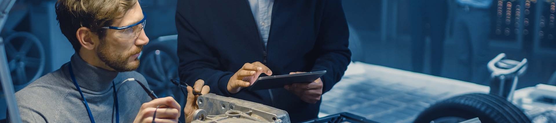 Two males looking at the diagnostics of a car