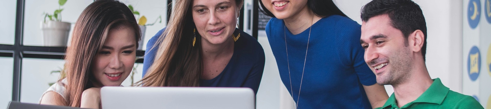 young people around a laptop discussing an issue