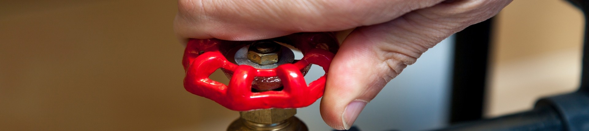 Close-up of the hand of an unseen person turning a valve