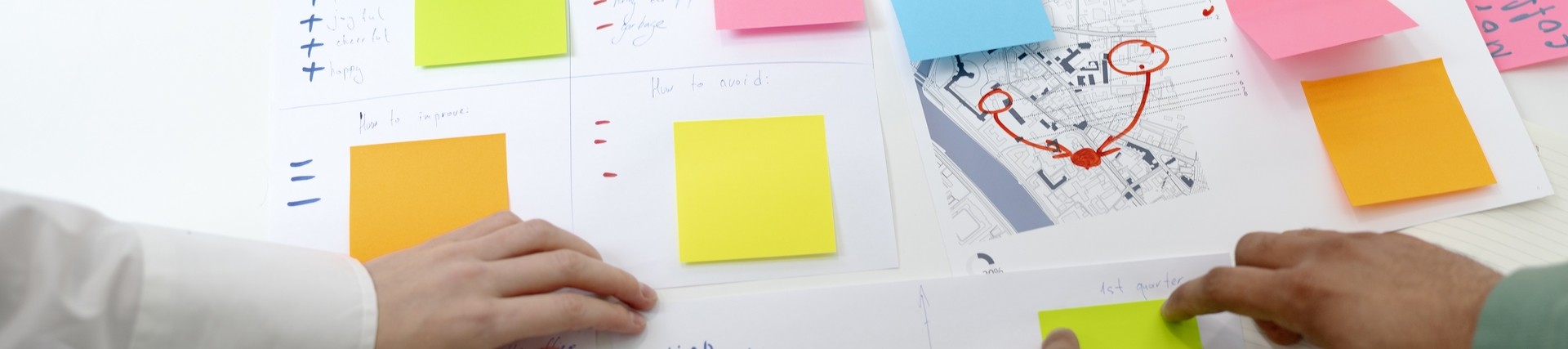 People brainstorming ideas through post it notes on table