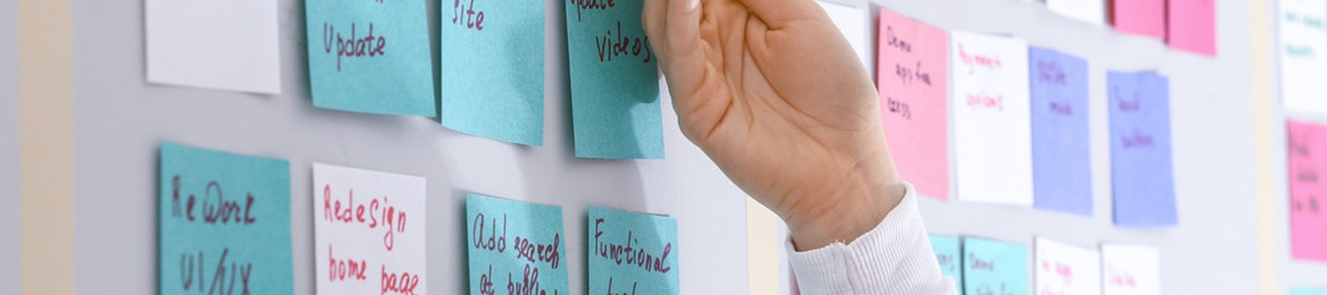 An unseen person looking at a board covered in sticky notes