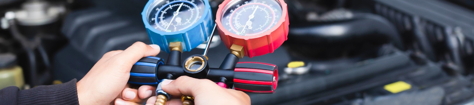 Upclose shot of hands performing air conditioning checks on a car engine