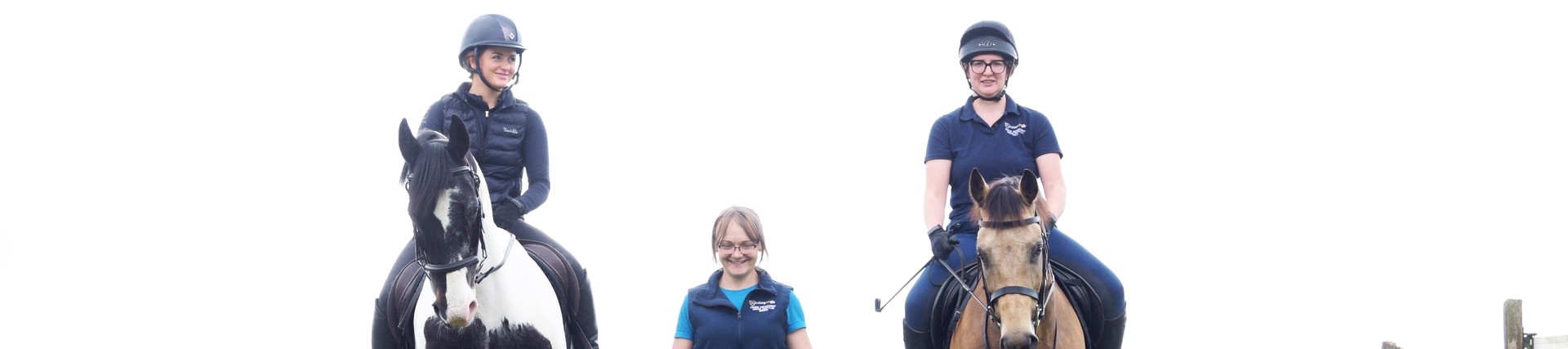 2 female students on horses walking with tutor