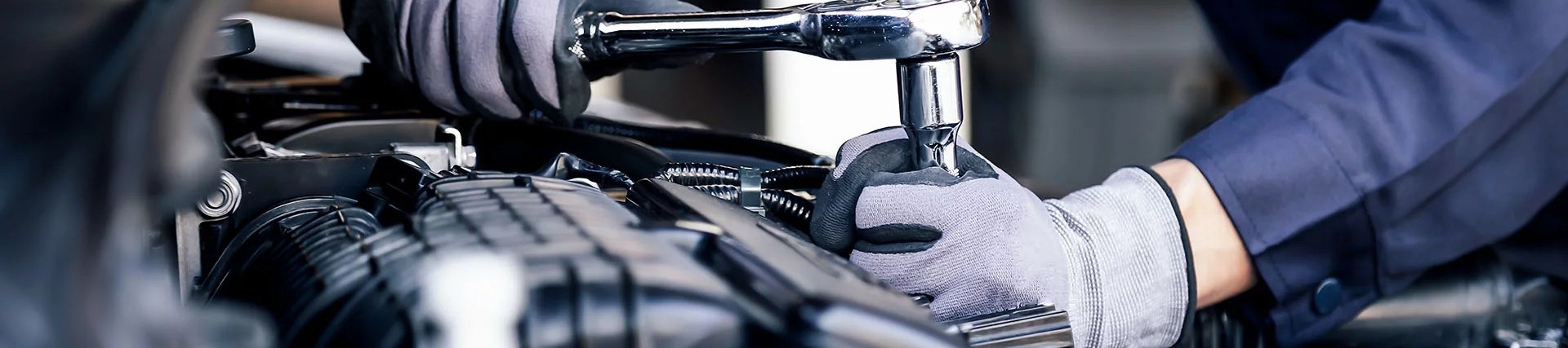 Close-up shot of the hands of an unseen person working on a car engine