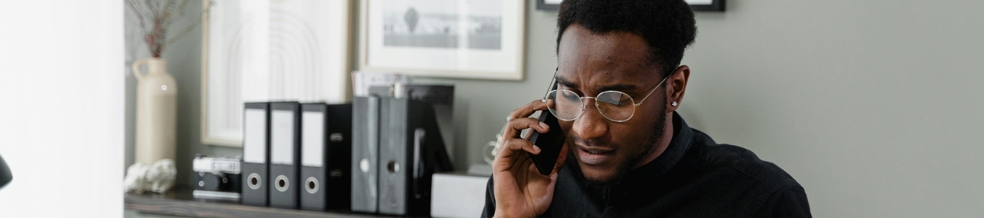 A person sitting at a desk on the phone