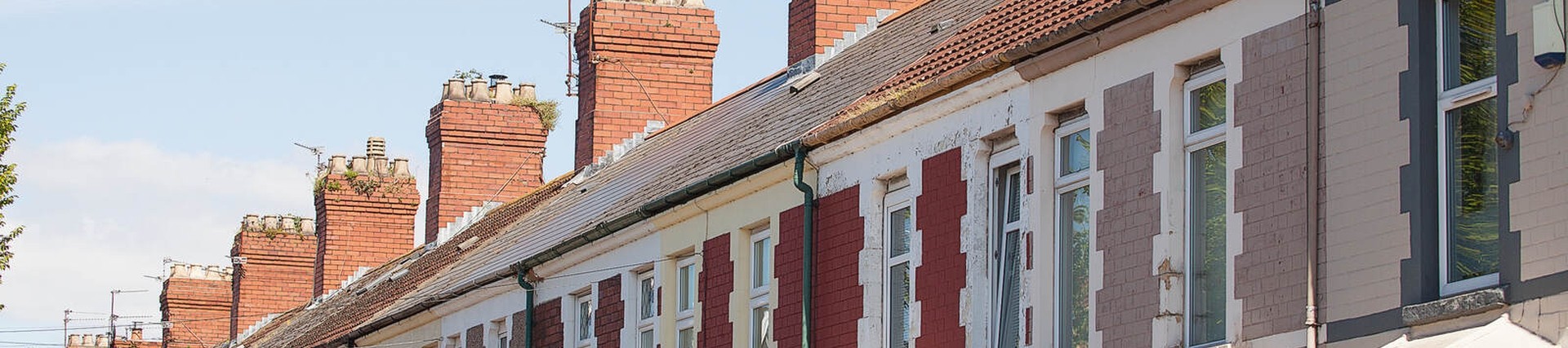 Exterior of UK terrace houses, blue sky in background