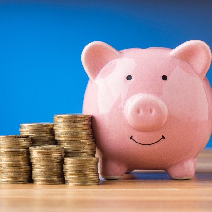 Piggy bank next to a pile of coins.