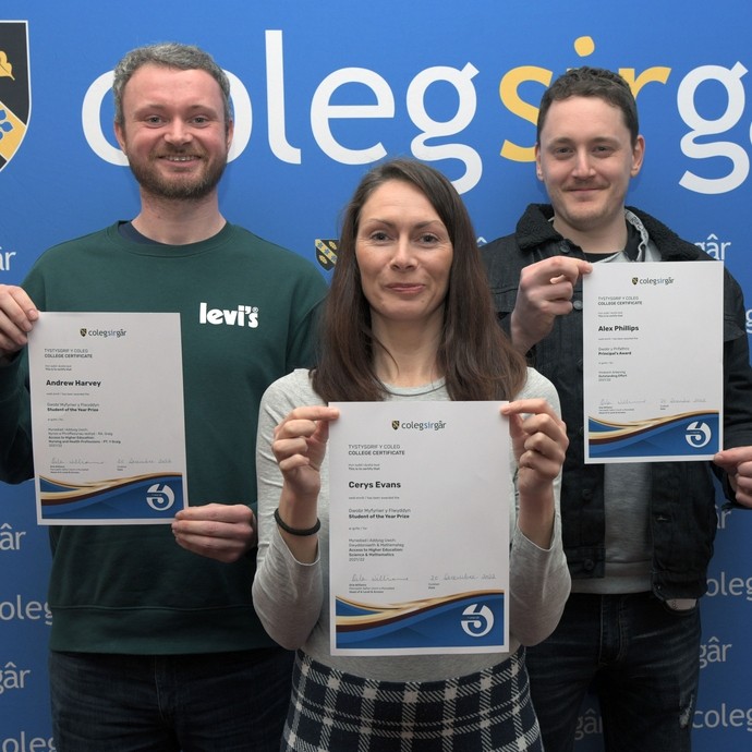 Three students with certificates