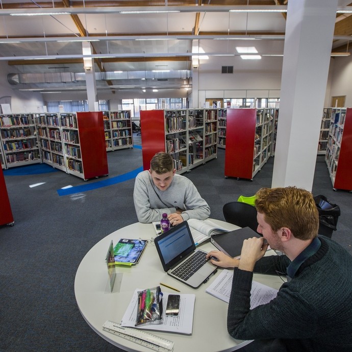 high up shot of a man working at a desk in the library