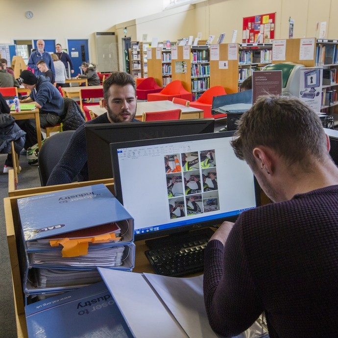 2 students working at computers in the library